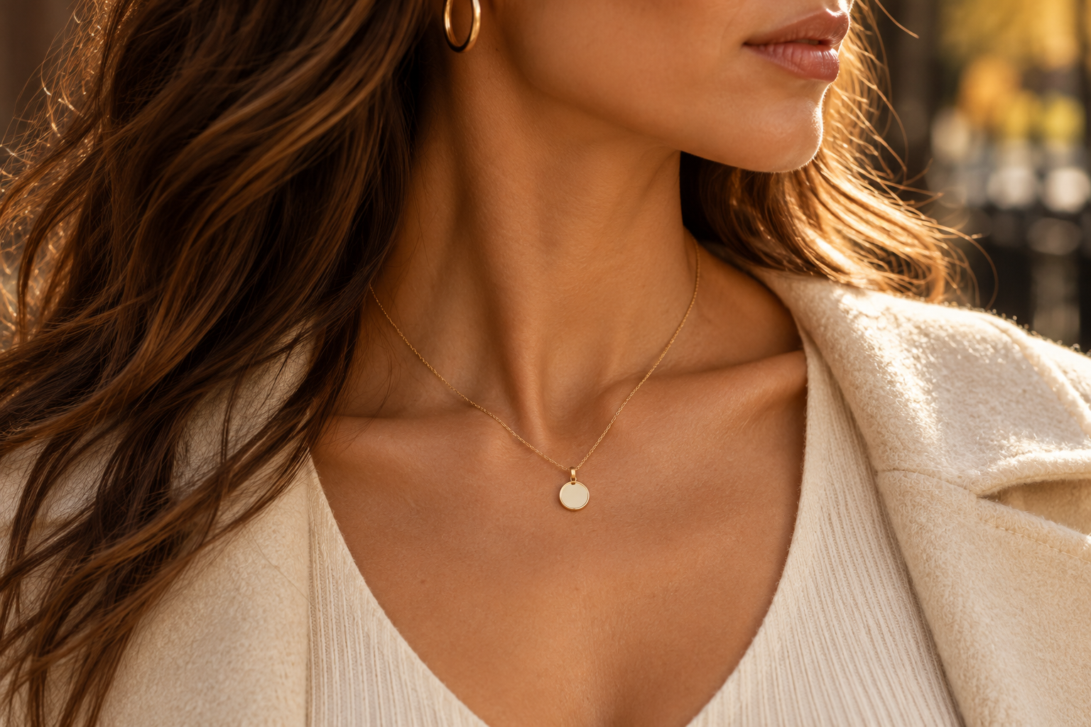 Gold necklace worn with a cream jacket